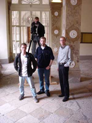 Matt auf Podest durch Kamera blickend, Detori, Cole und Cait im Erdgeschoß des Schloss Mirabell